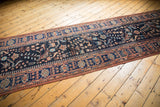 Long diagonal view of the vintage Persian runner's allover bird and floral field.