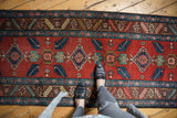 Brick red ground with repeating quatrefoil and floral motifs on the vintage Persian runner.