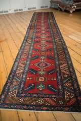 Repeating quatrefoil floral and bursting leaf motifs on brick red vintage Persian runner.