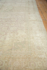 Distressed texture of a vintage Sivas carpet with faded floral motifs in muted tones.
