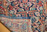 Vintage Sarouk runner's folded corner reveals hand-knotted foundation and traditional floral motifs.