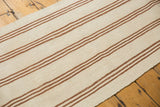 Hand-woven texture of the Turkish Kilim runner showing vertical ivory, coffee brown, and bronze stripes.