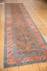 Textured Heriz runner with repeating medallions, playful florals, and serrated borders in madder red and sky blue.