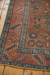 Heriz runner's madder red border, displaying serrated leaves and playful floral field motifs.