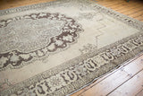 Worn chocolate brown patterns and antique ivory pile with exposed foundation on a distressed Oushak rug.