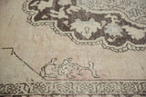Vintage distressed Oushak carpet pile showing chocolate brown pattern on antique ivory with blush.
