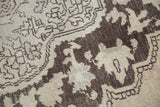 Distressed Oushak rug detail: chocolate brown and ivory tribal pattern with wear.
