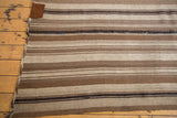 Handwoven vintage Moroccan Kilim texture, showing chocolate brown stripes with blue thread reinforcement.