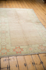 Distressed pale seafoam green border, cantaloupe starburst motifs, vintage Oushak rug.