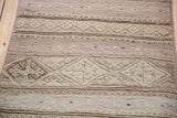 Close-up of the hand-woven texture and banded diamond motifs on a Jijim rug.