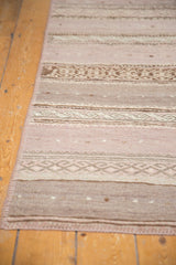 Angled view of the handwoven texture and geometric bands on a vintage Jijim runner.