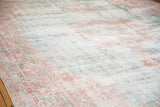 Distressed texture of a Sparta carpet, showing faded blush, ocean green, and ivory.