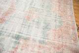 Distressed Sparta carpet with worn ocean green field and faded blush patterns.