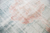 Faded blush, ocean green, and ivory hues on the distressed vintage Sparta carpet, showing wear across knot heads.