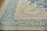 Distressed indigo blue floral vinery on the antique ivory border of a Kerman rug.