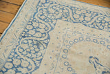 Distressed indigo blue floral border and vinery on antique ivory Kerman carpet.
