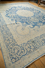 Indigo blue whimsical floral vinery and wispy waves on a distressed Kerman carpet.