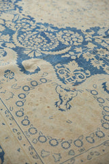 Detail of whimsical indigo blue floral wreaths and vinery on distressed Kerman carpet.