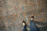 Distressed vintage Tabriz carpet, muted teal blue floral arabesques, and worn texture.