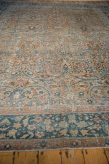 Distressed vintage Tabriz carpet's low pile reveals teal, beige scrolling arabesques and faint foundation.