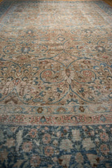 Distressed Persian Tabriz rug's scrolling floral arabesques, even wear, and faint foundation in beige, blue, blush.