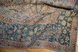 Decorative distressed teal indigo, blush, and sand floral patterns on a vintage Tabriz rug.