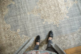 Vintage distressed Oushak rug with faded denim blue field and ivory scrolling vinery.