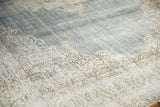 Distressed vintage Oushak border with scrolling vinery against a pale denim blue field.