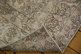 Corner of distressed vintage Oushak revealing worn vinery pattern and hand-knotted foundation.