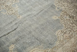 Distressed pale denim blue field with ornate beige curvilinear vinery in this vintage Oushak.