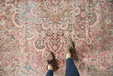 Distressed Persian Meshed carpet with faded raspberry and dusty teal floral vinery.