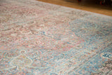 Distressed vintage Meshed carpet section, featuring intricate floral vinery in pale raspberry and dusty teal.