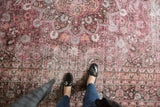 Distressed pile of vintage Meshed carpet, with fuscia, raspberry, charcoal floral details.