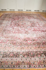 Distressed Persian Meshed carpet detail with fuscia, ivory, charcoal floral vinery and knot heads.