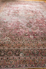 Distressed vintage Meshed carpet, intricate floral vinery and peach border with fuscia and charcoal.