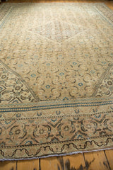 Distressed Mahal carpet corner showing faded copper khaki, indigo blue Herati design, and worn pile.