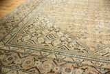 Distressed vintage Mahal rug corner with faded khaki, indigo, and charcoal Herati patterns.