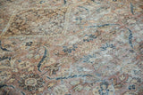 Distressed Mahal carpet's worn pile texture, showing muted chestnut and teal floral designs.