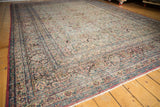 Distressed Khorassan rug corner with time-softened ivory, madder red, and pale blue vinery.