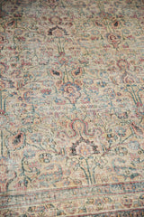 Textural distressed weave of the Khorassan rug, showing muted ivory, blue, and red palmettes.