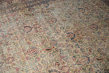 Distressed Khorassan rug detail: allover palmettes and vinery in ivory, blue, and red tones.