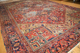 Vintage Heriz carpet's cherry red field detail with splayed floral, gold, and blue vinery.