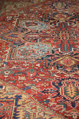 Heriz rug's dense field of sprawling vinery and floral elements in cherry red, blue, and gold.