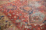 Vintage Heriz rug detail: cherry red, sky blue splayed floral motifs with textural pile.