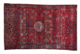 Deep cherry red Vintage Lilihan rug with central medallion, geometric floral motifs, and visible wear.