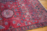 Vintage Lilihan rug's cherry red field, geometric floral motifs, and isolated wear.