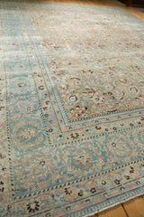 Faded sky blue border and distressed ivory field patterns of a vintage Meshed carpet corner.