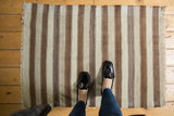Neutral striped hand woven Moroccan Kilim rug with natural ivory, gray, and brown tones.