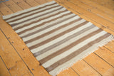 Natural wool tones and striations in the brown and ivory striped Moroccan Kilim rug.