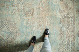 Distressed vintage Heriz rug's seafoam geometric pattern and worn texture underfoot.